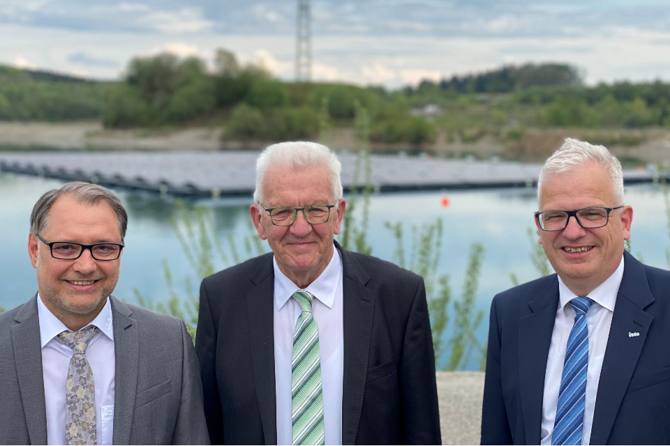 Ministerpräsident Kretschmann vor einer schwimmenden Photovoltaik-Anlage in Ostrach.